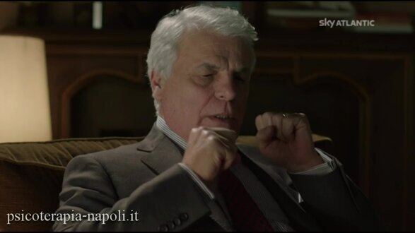 Michele Placido nei panni di Guido nella serie In Treatment, ritratto in primo piano con i pugni chiusi e gli occhi serrati mentre manifesta ansia e tensione emotiva in psicoterapia.